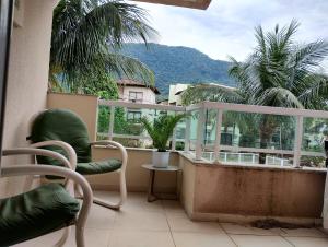 a balcony with a chair and a view of a mountain at Apartamento no Hotel Porto Marina Mangaratiba in Mangaratiba