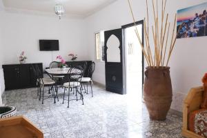 una sala da pranzo con tavolo, sedie e vaso di Private Villa halal 2 rooms swimming pool not overlooked a Marrakech