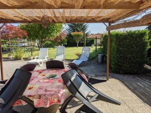 un grupo de sillas y una mesa en un patio en L'enclos, en Saint-Geours-de-Maremne