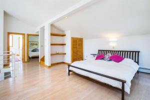a bedroom with a large white bed with pink pillows at Moon Hill Retreat in Londonderry
