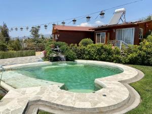 uma piscina com uma fonte no quintal de uma casa em Villarreal Lodge Hotel Ecológico em Totolapan