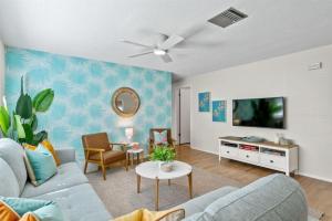 sala de estar con sofá y TV en Tropical Oasis FL Largo, en Largo