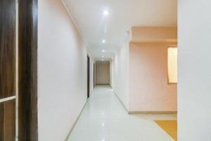 um corredor de um edifício com paredes brancas e pisos brancos em HARIDHAM GUEST HOUSE em Vrindavan