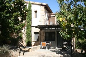 a house with a table and chairs in front of it at Maset del Riu in Valderrobres