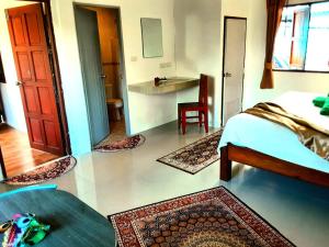 een slaapkamer met een bed en een kamer met tapijten bij Central Essence in Haad Chao Phao