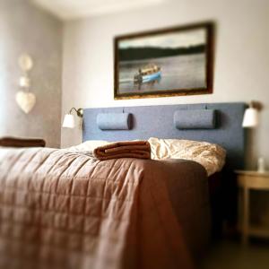 1 dormitorio con 1 cama con una pintura en la pared en Photoeverhome, en Bengtsfors