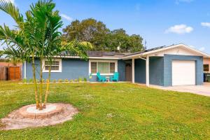 una casa azul con una palmera en el patio en Tropical Oasis FL Largo, en Largo