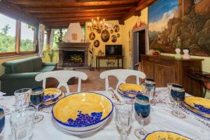 una mesa con placas y vasos azules y amarillos. en Guest House: Casa dei Lillà, en Bellegra