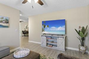 a living room with a flat screen tv on a wall at Tropical Oasis FL Pinellas Park in Pinellas Park