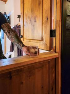 un hombre con un tatuaje sosteniendo una taza en un mostrador en The Love Shack Big Bear, en Sugarloaf 24 fotos más