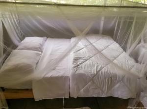 uma cama branca com dossel num quarto em MALOKA LODGE em Iquitos