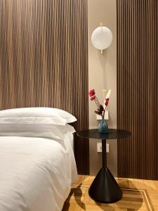 - une chambre avec un lit et une table fleurie dans l'établissement My Milano Charming & Luxury Rooms, à Milan
