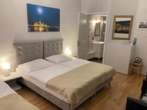 ein Schlafzimmer mit einem großen Bett mit einem Bild an der Wand in der Unterkunft Anabelle Bed and Budapest in Budapest