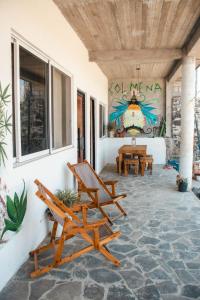 a porch with rocking chairs and a painting on the wall at Casa Colmena in Tlayacapan