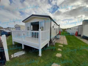 a tiny house is sitting on the grass at Pet friendly caravan in Walton on the Naze in Walton-on-the-Naze