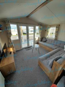 a living room with a couch and a table at Pet friendly caravan in Walton on the Naze in Walton-on-the-Naze