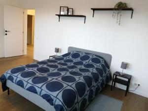 um quarto com uma cama com um edredão azul em modern cosy luxury apartement em Antuérpia