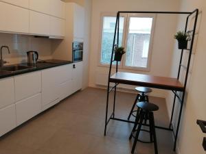 una cocina con encimera y mesa. en modern cosy luxury apartement, en Amberes