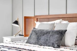 a bed with black and white pillows and a lamp at New ElectricCity Junior Penthouse Unit 3, Near Proctors in Schenectady