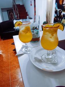 Dois copos de sumo de laranja numa mesa. em Confort Putumayo em Mocoa