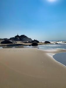 una playa de arena con el océano en el fondo en CasaPiedra en Puerto Escondido