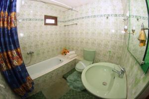 y baño con bañera, aseo y lavamanos. en Heavenly Home Inn, en Nuwara Eliya