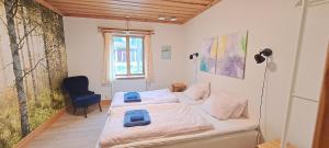 Viksjöfors的住宿－Skålsjögården Timber Lodge，一间小卧室,配有两张床和椅子