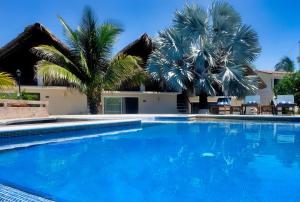 uma piscina com palmeiras e um edifício em CasaPiedra em Puerto Escondido