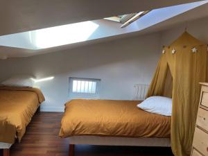 ein Schlafzimmer mit zwei Betten und einem Dachfenster in der Unterkunft Moulin de l’aubier in Fouras