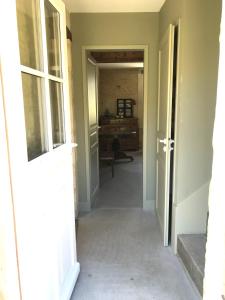 un couloir dans une maison avec une porte ouverte dans l'établissement Les Granges Pelloquin, à Bernières-sur-Mer