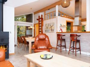 uma sala de estar com lareira e uma mesa e cadeiras em Holiday home Ebeltoft CL em Ebeltoft