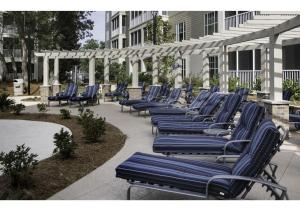 a row of blue lounge chairs on a patio at Myrtle Beach Bike Week - Spring Rally - Deluxe Studio Villa Retreat Resort - Special Offer Now! in Myrtle Beach