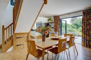 ein Esszimmer mit einem Holztisch und Stühlen in der Unterkunft Contemporary Barn Waveney Valley in Harleston