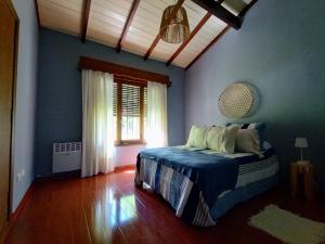 een slaapkamer met een bed met blauwe muren en een raam bij Aires de Miramar HOLA SUR in Miramar
