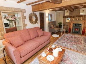 sala de estar con sofá y mesa en Toll Bar Cottage, en Bakewell