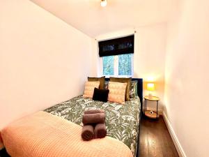 a bedroom with a bed with a teddy bear on it at Rustic Elegant 2Bedroom Haven near Regents Park in London