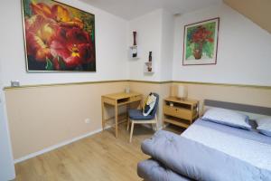 Dormitorio con cama, escritorio y pintura en Nov Sweety Home en Goussainville