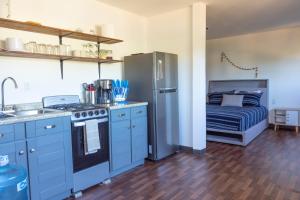 una cucina con armadi blu, frigorifero e letto di EXPERIENCE a Pescadero
