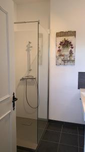 uma casa de banho com um chuveiro e uma cruz na parede em Chambres d'hôtes Domaine des Formes em Effiat