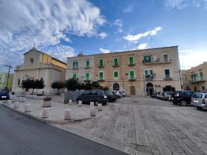 a parking lot with cars parked in front of a building at Piazzimmacolata53 in Molfetta