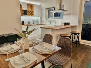 a dining room with a table and chairs with wine glasses at Rustic Elegant 2Bedroom Haven near Regents Park in London