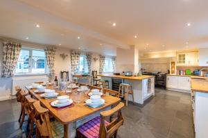 a kitchen and dining room with a wooden table and chairs at Spreacombe Lodge in Woolacombe