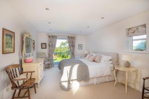 a bedroom with a bed and a desk and a window at Spreacombe Lodge in Woolacombe