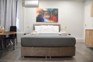 una camera da letto con un letto e un dipinto sul muro di Athens Panormou Central Apartment Zeus by SuperHost Hub ad Atene