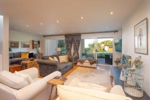 a living room with white furniture and a large window at Spreacombe Lodge in Woolacombe