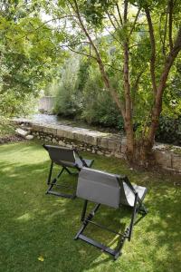 a chair sitting on the grass in a yard at Hotel Els Encantats in Espot