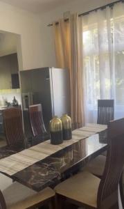 uma cozinha com uma mesa com cadeiras e um frigorífico em Silverest Sanctuary: Home away from Home em Lusaka