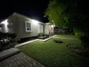 a yard of a house at night with lights at Silverest Sanctuary: Home away from Home in Lusaka