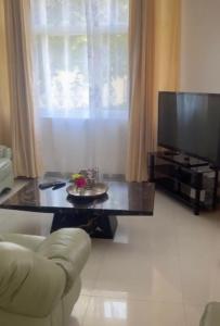 a living room with a coffee table and a television at Silverest Sanctuary: Home away from Home in Lusaka