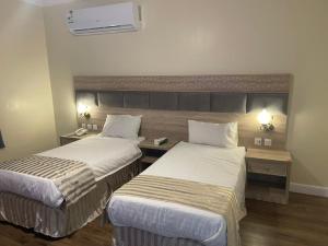 Habitación de hotel con 2 camas y escritorio en فندق نزهة النسيم, en Ash Shishah
